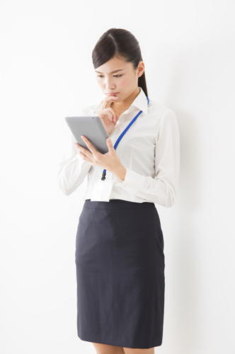 タブレットを持って考える女性